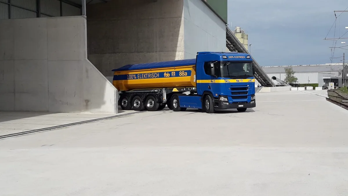 Ein in den Farben Blau und Gelb gehaltener Sattelschlepper der Firma FBB von Scania. Das Fahrzeug fährt batterieelektrisch.